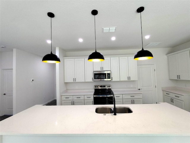 kitchen with hanging light fixtures, stainless steel appliances, and white cabinets