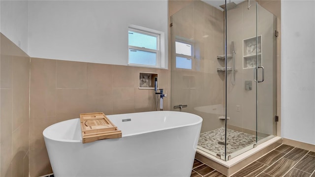 bathroom featuring independent shower and bath and tile walls