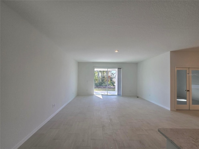 unfurnished room with a textured ceiling