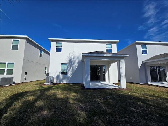 rear view of house featuring cooling unit, a patio area, and a lawn