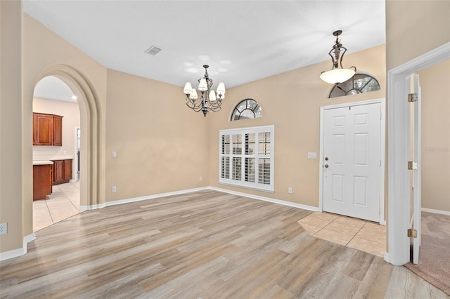 foyer with a notable chandelier and light hardwood / wood-style flooring