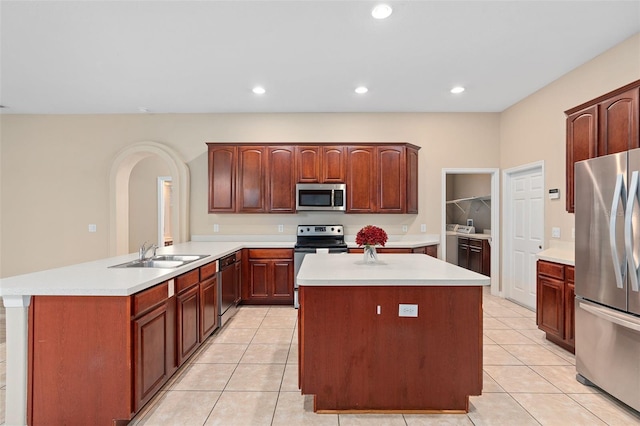 kitchen featuring a center island, sink, kitchen peninsula, and appliances with stainless steel finishes