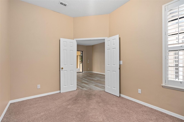 carpeted spare room featuring a healthy amount of sunlight