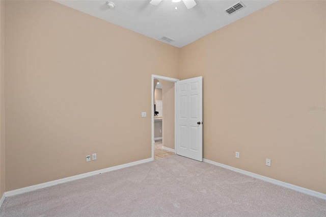 carpeted spare room featuring ceiling fan