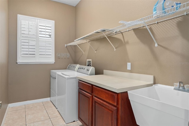 washroom featuring sink, light tile patterned floors, cabinets, and washing machine and clothes dryer