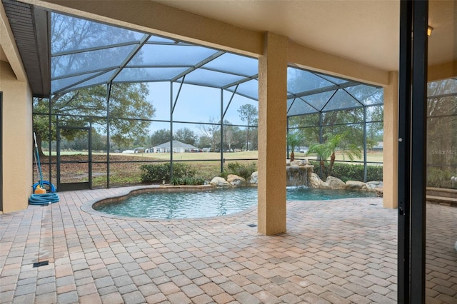 view of swimming pool featuring pool water feature, a lanai, and a patio area