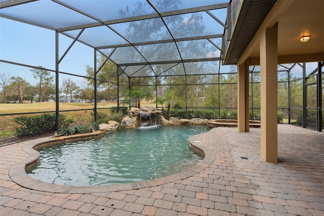 view of pool featuring a jacuzzi, a patio area, pool water feature, and glass enclosure