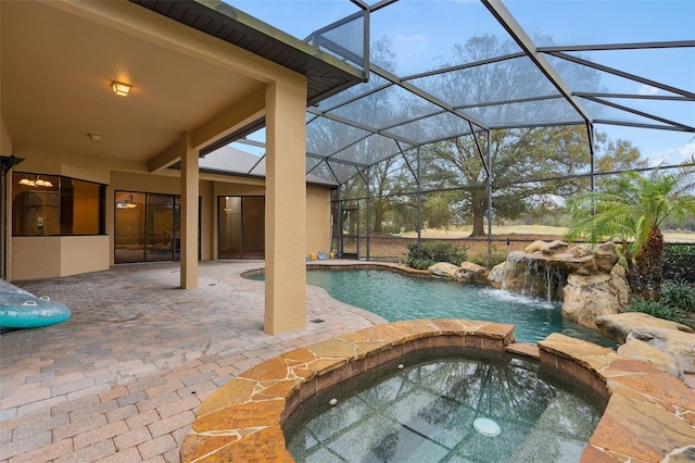 view of pool with an in ground hot tub, pool water feature, a lanai, and a patio area