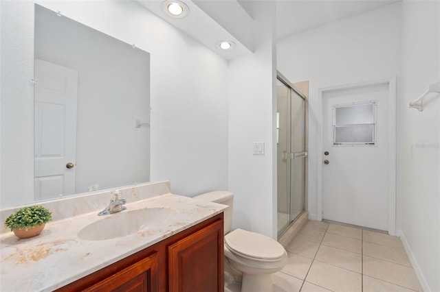 bathroom featuring tile patterned floors, toilet, a shower with door, and vanity