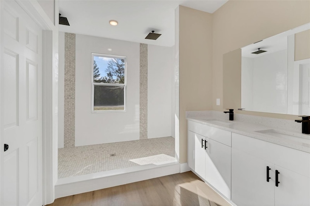 bathroom featuring vanity, tiled shower, and hardwood / wood-style floors