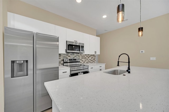 kitchen with sink, light stone counters, appliances with stainless steel finishes, pendant lighting, and backsplash