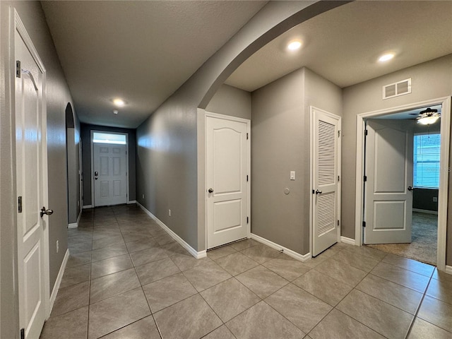 hall featuring light tile patterned floors