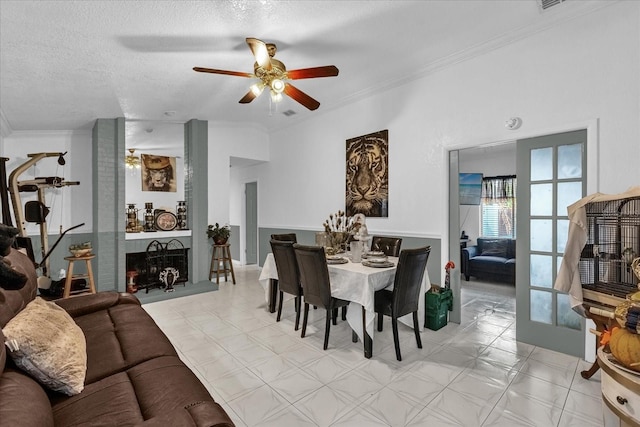 dining area with crown molding, a fireplace, light tile patterned flooring, and a textured ceiling