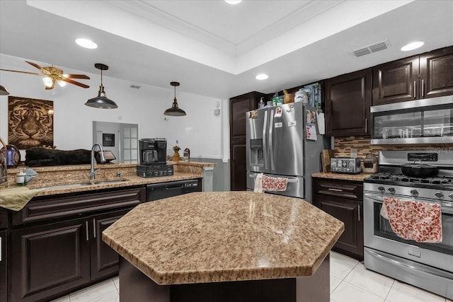 kitchen with pendant lighting, sink, dark brown cabinets, stainless steel appliances, and a center island