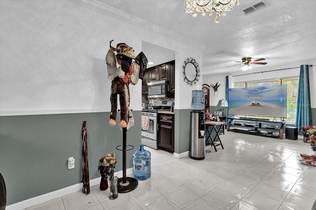 kitchen with appliances with stainless steel finishes, ceiling fan, crown molding, dark brown cabinets, and a textured ceiling