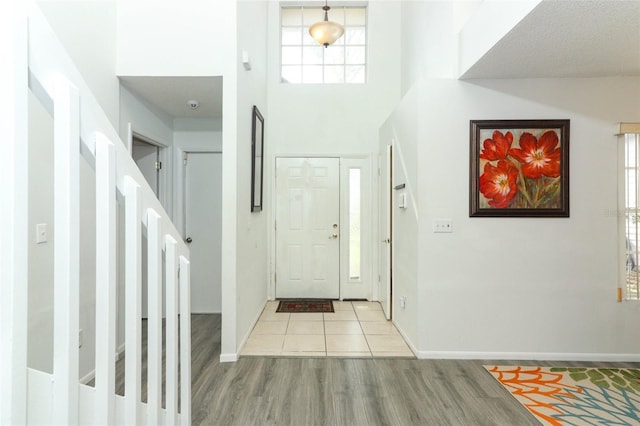 entryway with a towering ceiling and light hardwood / wood-style floors