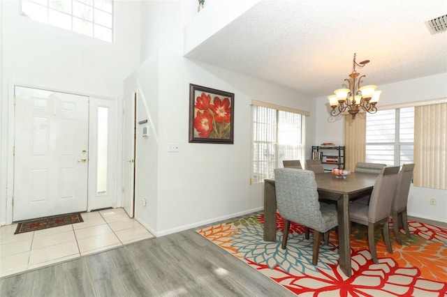 dining room featuring a chandelier, light hardwood / wood-style floors, and a textured ceiling