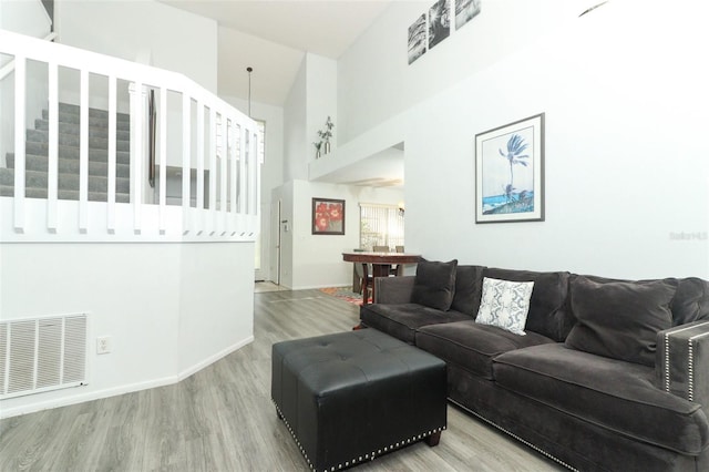 living room with hardwood / wood-style floors and a high ceiling