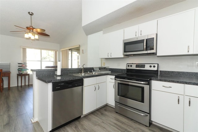 kitchen featuring sink, dark wood-type flooring, stainless steel appliances, white cabinets, and kitchen peninsula