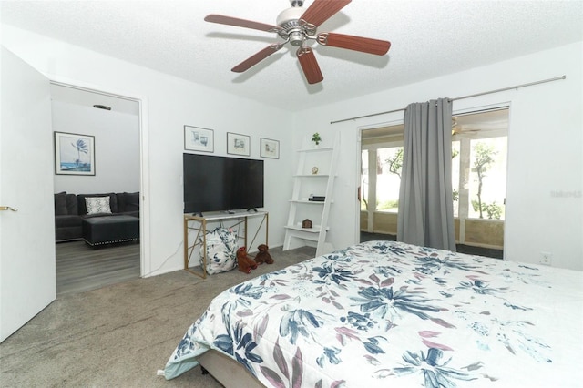 carpeted bedroom with ceiling fan, access to exterior, and a textured ceiling