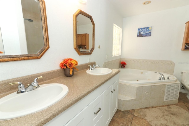 bathroom featuring tiled tub, vanity, and tile patterned floors