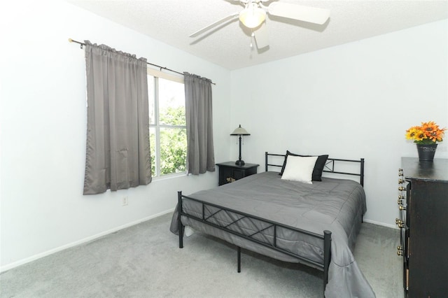 carpeted bedroom featuring ceiling fan and a textured ceiling