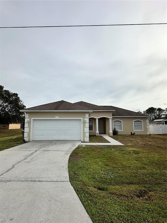 single story home featuring a garage and a front lawn