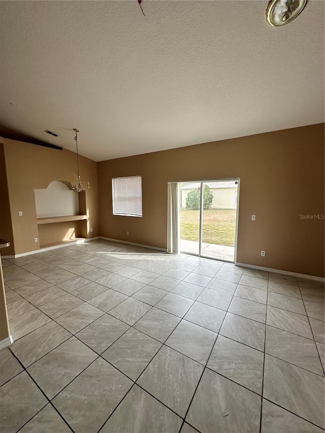 unfurnished living room featuring an inviting chandelier, a textured ceiling, and light tile patterned floors