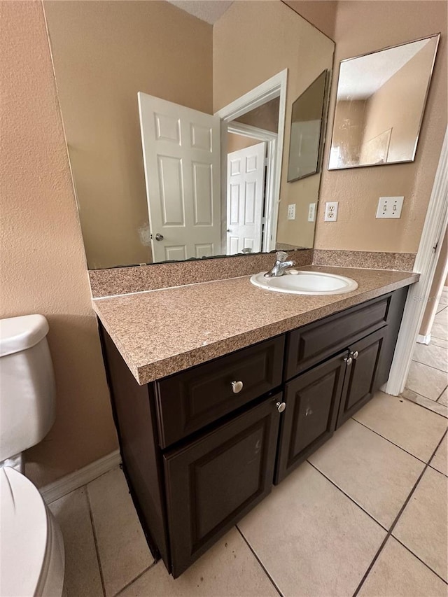 bathroom featuring tile patterned flooring, vanity, and toilet