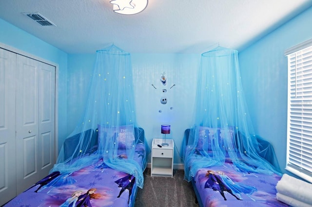 carpeted bedroom featuring a textured ceiling