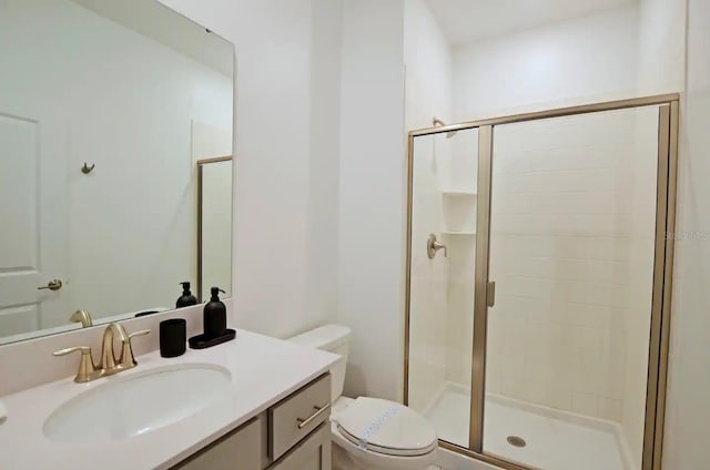 bathroom featuring vanity, toilet, and a shower with door