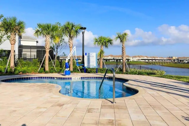 view of swimming pool featuring a patio area and a water view