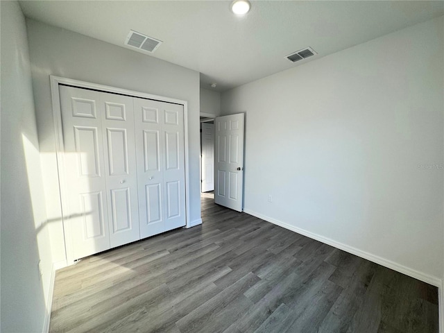 unfurnished bedroom featuring hardwood / wood-style floors and a closet