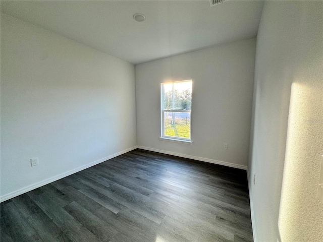 unfurnished room with dark wood-type flooring