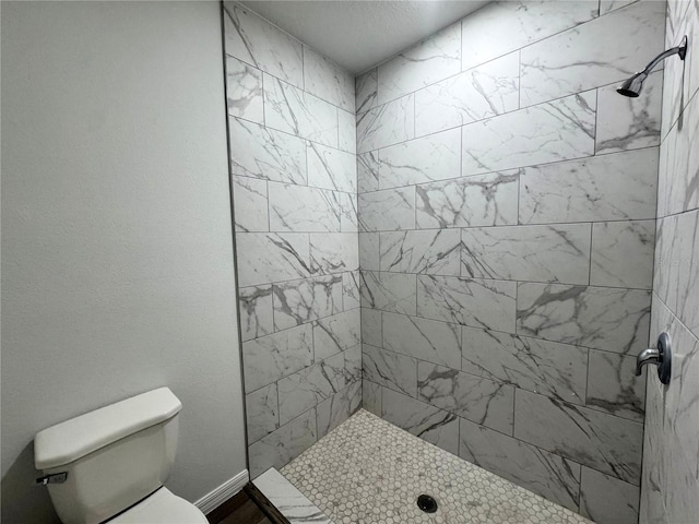 bathroom with tiled shower and toilet