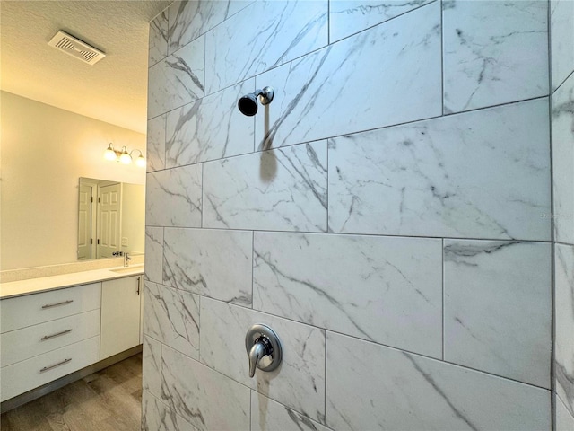 bathroom featuring vanity, wood-type flooring, and a textured ceiling