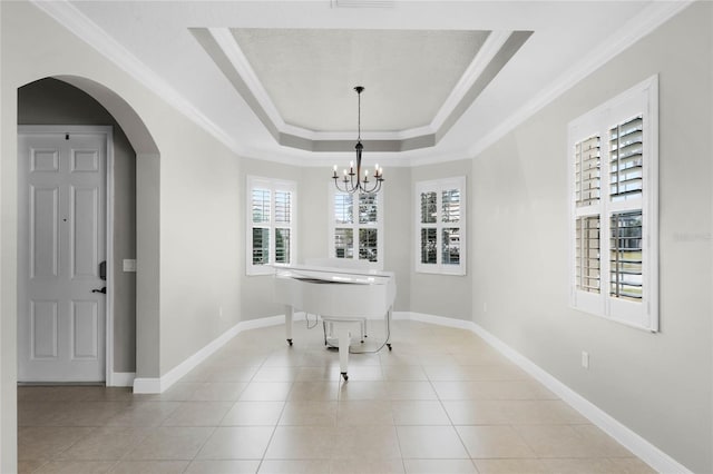 dining space featuring a raised ceiling, crown molding, light tile patterned flooring, and a chandelier