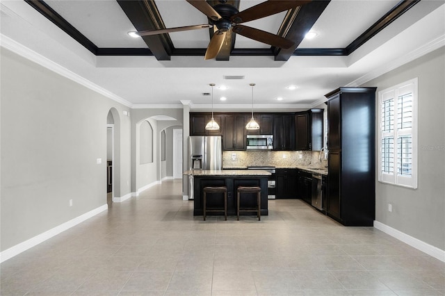 kitchen featuring a breakfast bar, a center island, hanging light fixtures, stainless steel appliances, and decorative backsplash