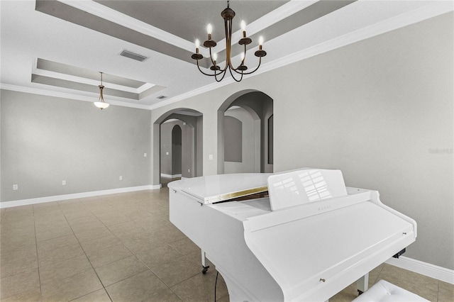 dining area featuring crown molding, a tray ceiling, and a notable chandelier