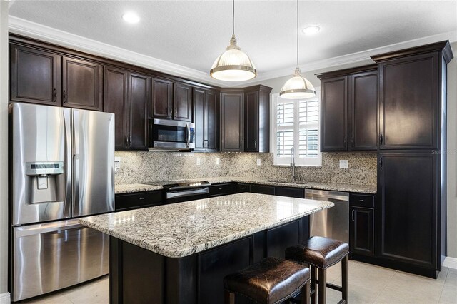 kitchen with sink, stainless steel appliances, a center island, decorative backsplash, and decorative light fixtures