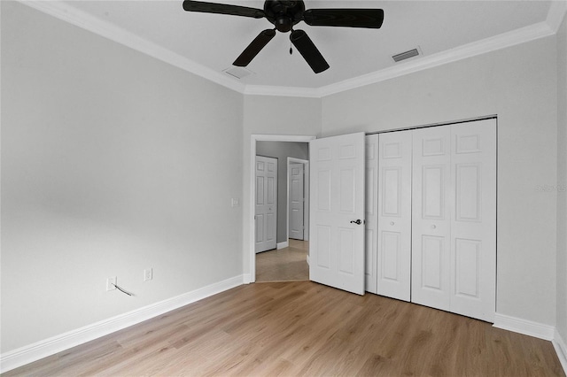 unfurnished bedroom with light hardwood / wood-style flooring, ornamental molding, and a closet