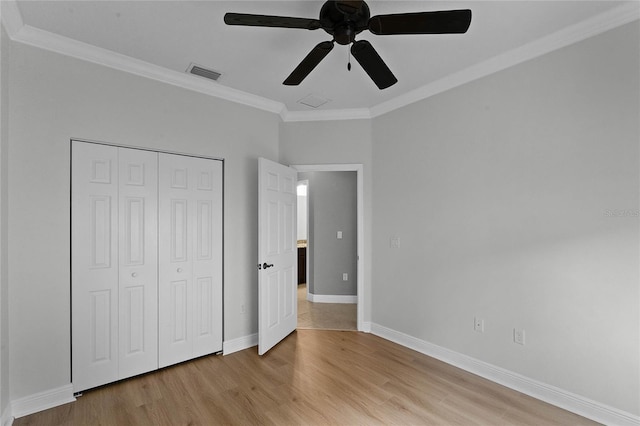 unfurnished bedroom featuring a closet, ceiling fan, crown molding, and light hardwood / wood-style flooring