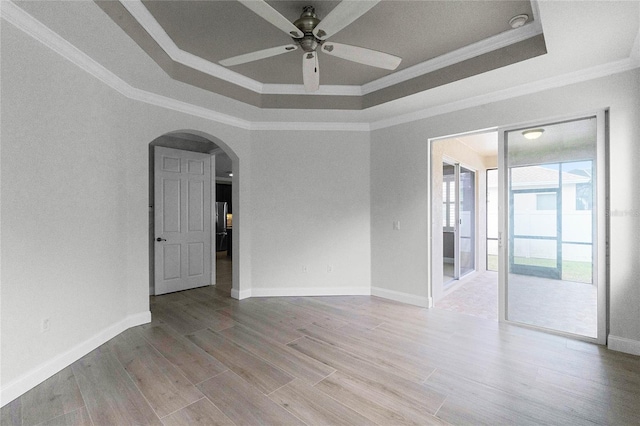 spare room with a raised ceiling, crown molding, and hardwood / wood-style floors