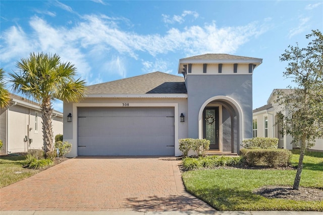 mediterranean / spanish home with a garage and a front lawn