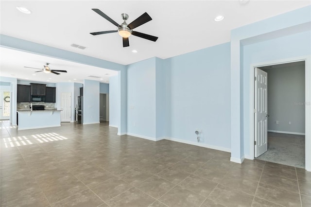 unfurnished living room with ceiling fan