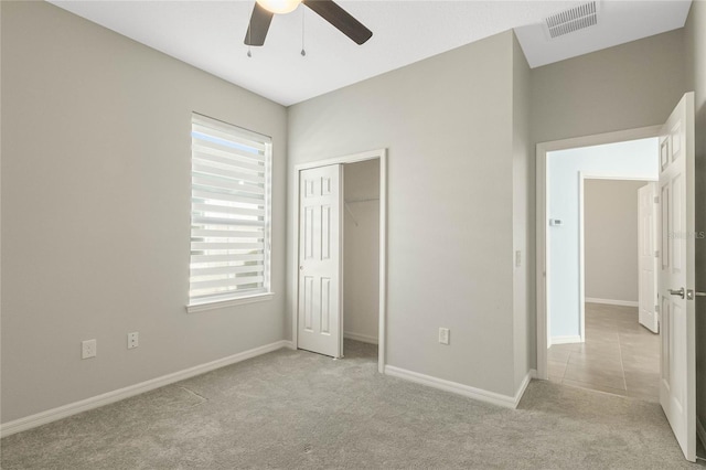 unfurnished bedroom featuring light colored carpet, a closet, and ceiling fan