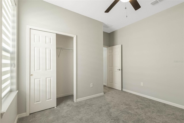 unfurnished bedroom with ceiling fan, light colored carpet, and a closet