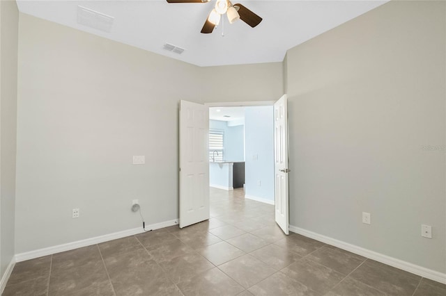 empty room with tile patterned flooring and ceiling fan