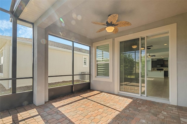 unfurnished sunroom with ceiling fan