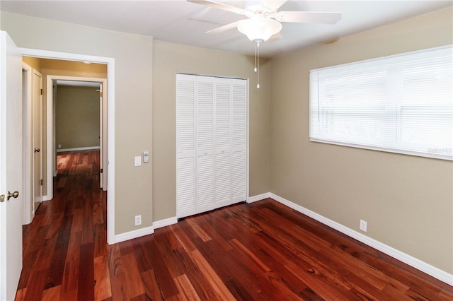 unfurnished bedroom with dark hardwood / wood-style floors, a closet, and ceiling fan